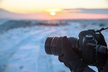 man hand camera in snowy landscape