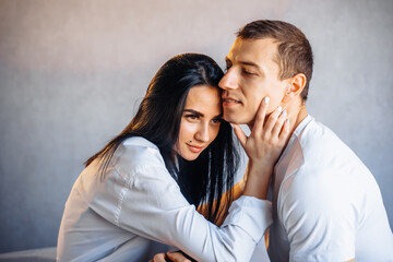 Young sexy brunette girl takes the initiative in sexual relationship with her boyfriend. Kisses him persistently, seducing him with her attractive body. Young romantic lovers intimate moments