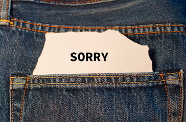 Sorry auf weißem Zettel in der Tasche einer Jeans.