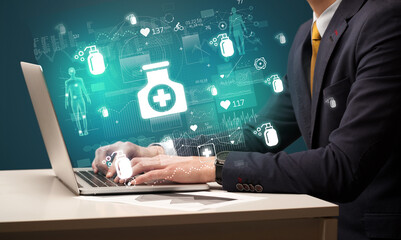 hand browsing on the internet for medical issues with medication icons coming out from the screen