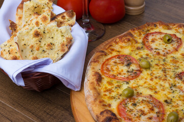 ricardo fernando franca junior pizza mussarela muçarela mucarelPhotograph of a delicious Mozzarella Cheese Pizza with slices of red tomatoes and green olives. Portion of crostinis seasoned.