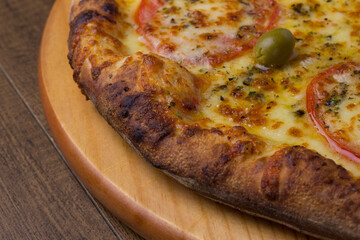 ricardo fernando franca junior pizza mussarela muçarela mucarelClose-Up Photograph of a Mozzarella Cheese Pizza with Sliced ​​Red Tomatoes on a Wooden Board. Macro photography.