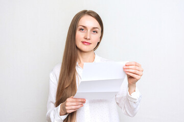 Pretty young woman reading a letter, white background