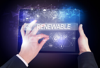 Obraz premium Close-up of a tablet searching RENEWABLE inscription, hi-tech computing concept