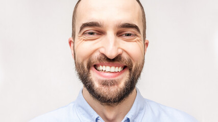 Fototapeta premium Laughing bearded man smiling and looking in the camera, portrait, close up, toned, 16:9, copy space