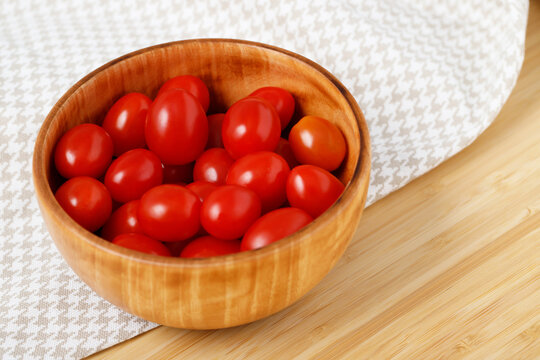 tomato in bowl and apron on wooden background. Prepare ingredients vegetable salad of fresh, Healthy food.
