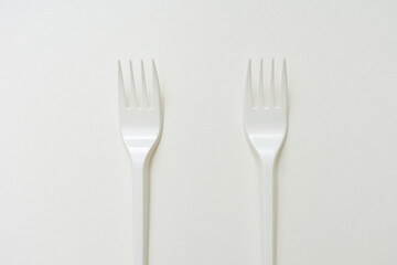 Top view of two plastic forks, white background, copy space