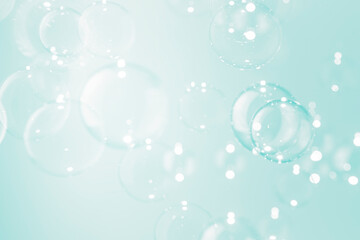 Beautiful blur transparent soap bubbles float on soft green background.