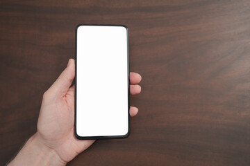 Man hand hold phone with white screen over black walnut table background