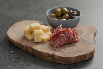 olives, salami and vintage cheese on concrete countertop