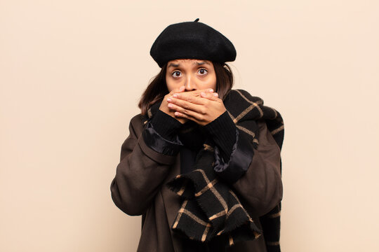 hispanic woman covering mouth with hands with a shocked, surprised expression, keeping a secret or saying oops