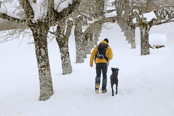 senderista montañero con grampones en la nieve y perro negro país vasco 4M0A7690-as21