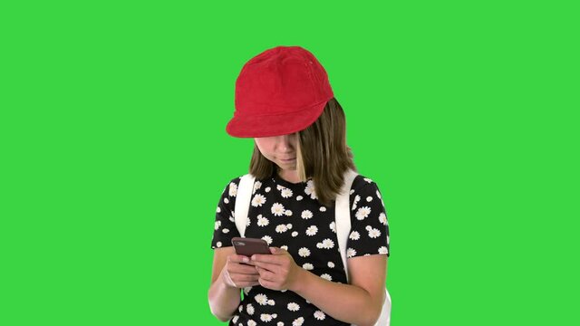 School girl checking her mobile phone on a Green Screen, Chroma Key.