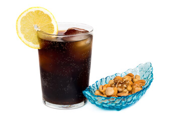 Refresco de cola con una rodaja de limón acompañado por aperitivos de frutos secos