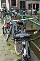 Obraz premium Parked bicycles on the canal in Amsterdam. Vertical.