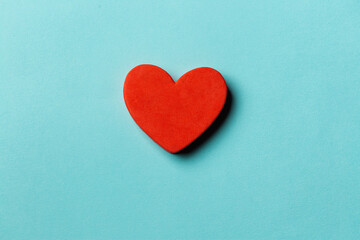 Red heart shape over blue paper background