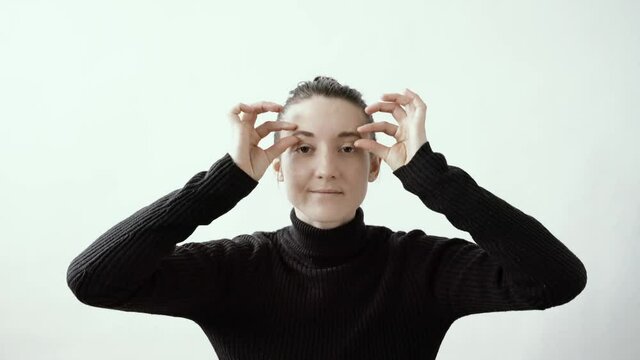 Woman is Massaging Her Eyebrows, Doing Facial Yoga Exercises in Studio. Anti Aging and Luxury Concept