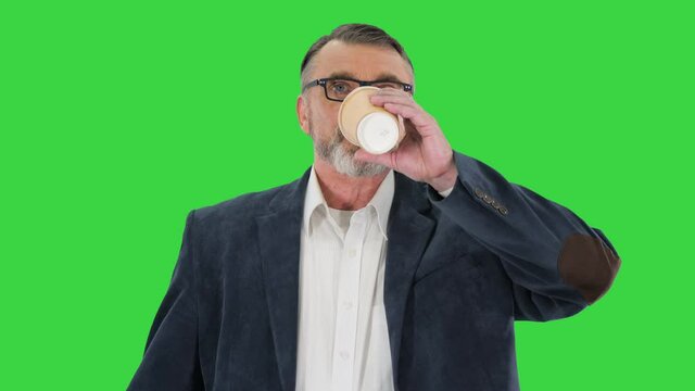 Rich mature man walking and drinking coffee on a Green Screen, Chroma Key.