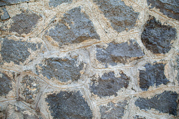 Abstract background of an antique stone wall of a house in the city of Pompeii, which died from a volcanic eruption. Close-up.