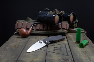 Game hunter set. Smoking pipe, knife and binoculars.