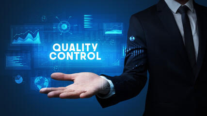 Hand of Businessman holding QUALITY CONTROL inscription, business success concept