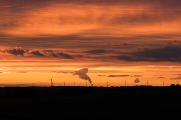 Sunset over windmills and fields
