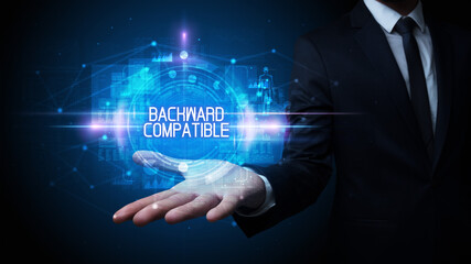 Man hand holding BACKWARD COMPATIBLE inscription, technology concept