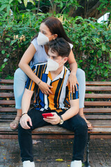Young couple in the park with disposable masks