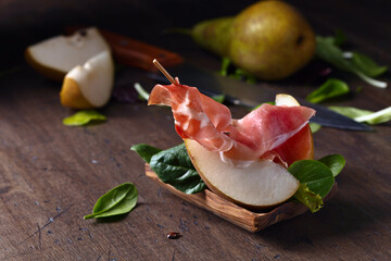 prosciutto with pear on a wooden table