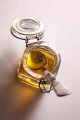 detail of agave syrup in glass jar with spoon inside. White background