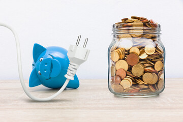 Sparschwein mit Stromstecker und Münzen