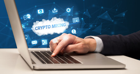 Businessman working on laptop with CRYPTO MINING inscription, modern technology concept