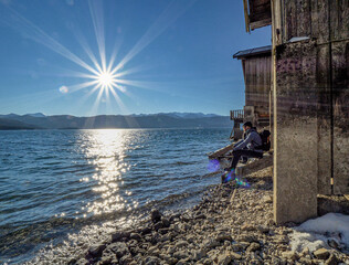 Fototapeta na wymiar Happy Man hike along a Bavarian lake during blue sky sunshine