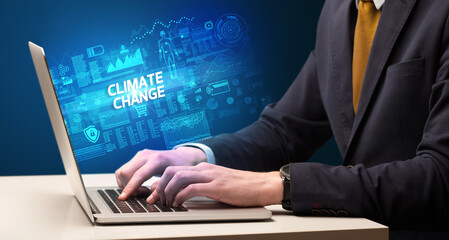 Fototapeta na wymiar Businessman working on laptop with CLIMATE CHANGE inscription, cyber technology concept