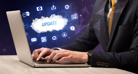 Businessman working on laptop with UPDATE inscription, modern technology concept