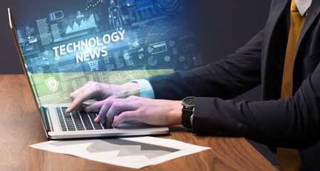 Businessman working on laptop with TECHNOLOGY NEWS inscription, cyber technology concept