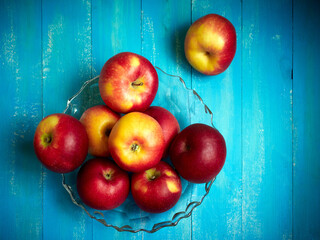 Bright red and yellow apples on a blue background.
