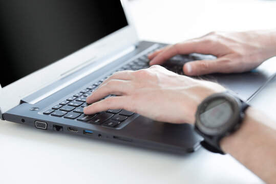 Person typing on a laptop. White background and black screen for text or image