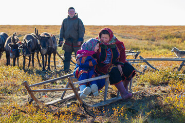 The extreme north, Yamal, the past of Nenets people, the dwelling of the peoples of the north, a family photo near the yurt in the tundra. - obrazy, fototapety, plakaty