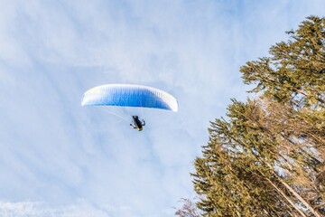 Startender Hobby Gleitschirm Flieger an einem Berghang mit professioneller Ausrüstung im Herbst, Deutschland