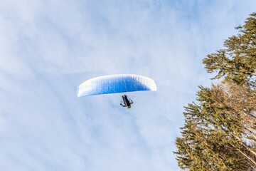 Startender Hobby Gleitschirm Flieger an einem Berghang mit professioneller Ausrüstung im Herbst,...