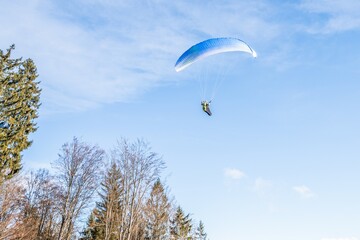 Startender Hobby Gleitschirm Flieger an einem Berghang mit professioneller Ausrüstung im Herbst,...
