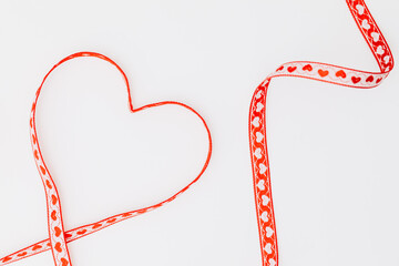 red heart on white. Heart shape from red gift ribbon on a white background. Copy paste
