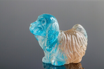 beautiful statuette of a dog from the mineral topaz on a gray background