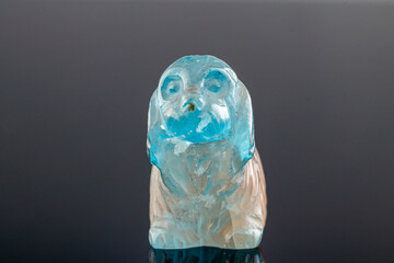 beautiful statuette of a dog from the mineral topaz on a gray background