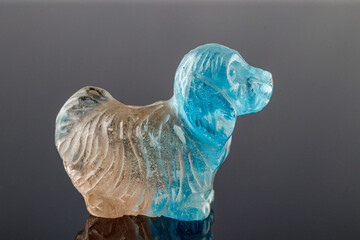 beautiful statuette of a dog from the mineral topaz on a gray background