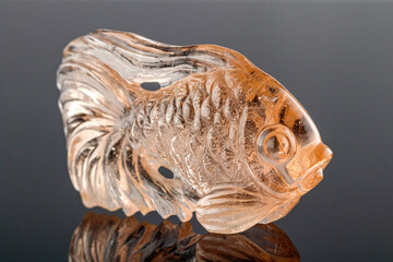 beautiful figurine fish made of topaz on a gray background