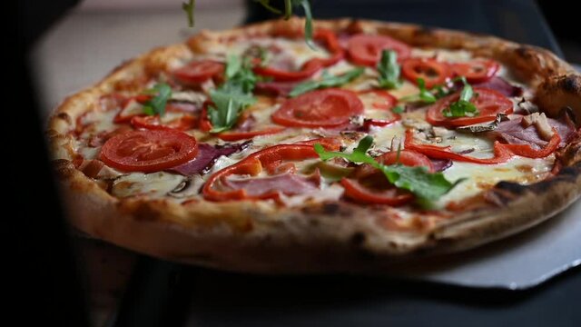 The chef takes out the pizza from the oven