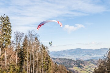 Fliegender Hobby Gleitschirm Flieger an einem Berghang mit professioneller Ausrüstung im Herbst...