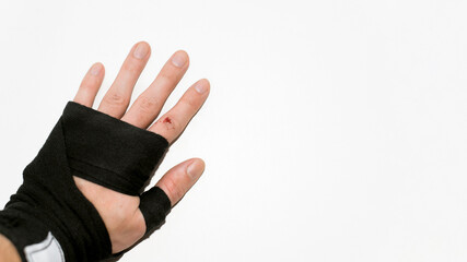Open wound on the finger. Palm in boxing bandage on a white background, copy space. Training trauma. Injury sport concept.